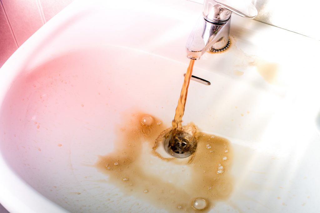 rusty-water-flowing-out-of-household-faucet-into-sink