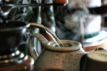 water-stream-pouring-into-ceramic-teapot-with-steam-rising-out