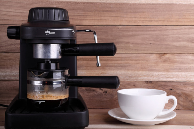 espresso machine making cup of coffee against wooden backsplash