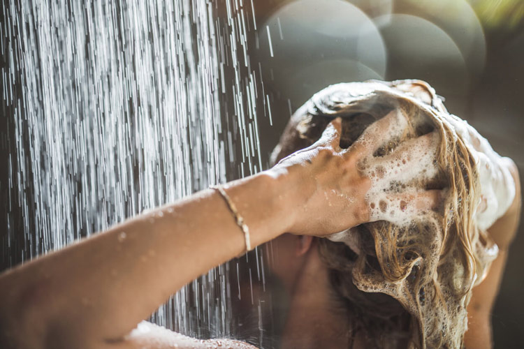 woman-washing-blond-hair-under-shower