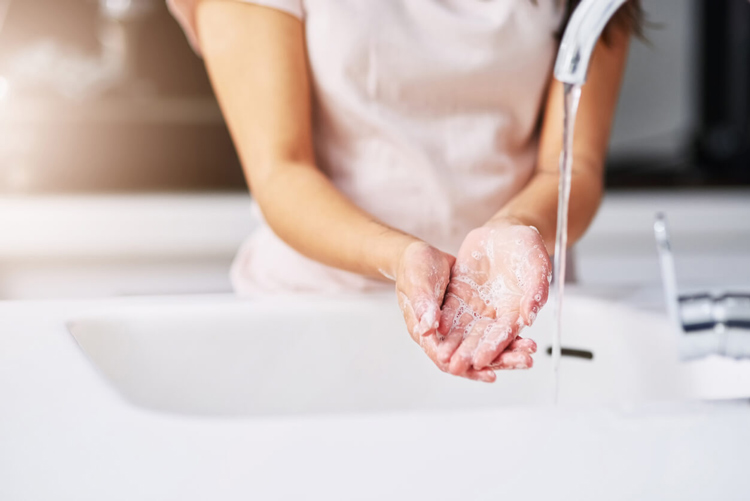 cropped-shot-of-woman-washing-hands-with-soap-and-water-at-kitchen-sink