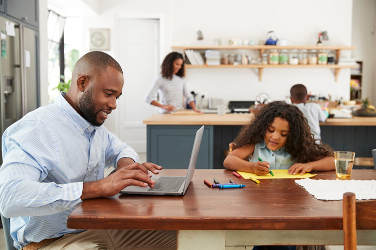 happy-family-in-kitchen-with-father-working-from-home-at-table-mother-at-counter-daughter-coloring-at-table-and-son-at-counter